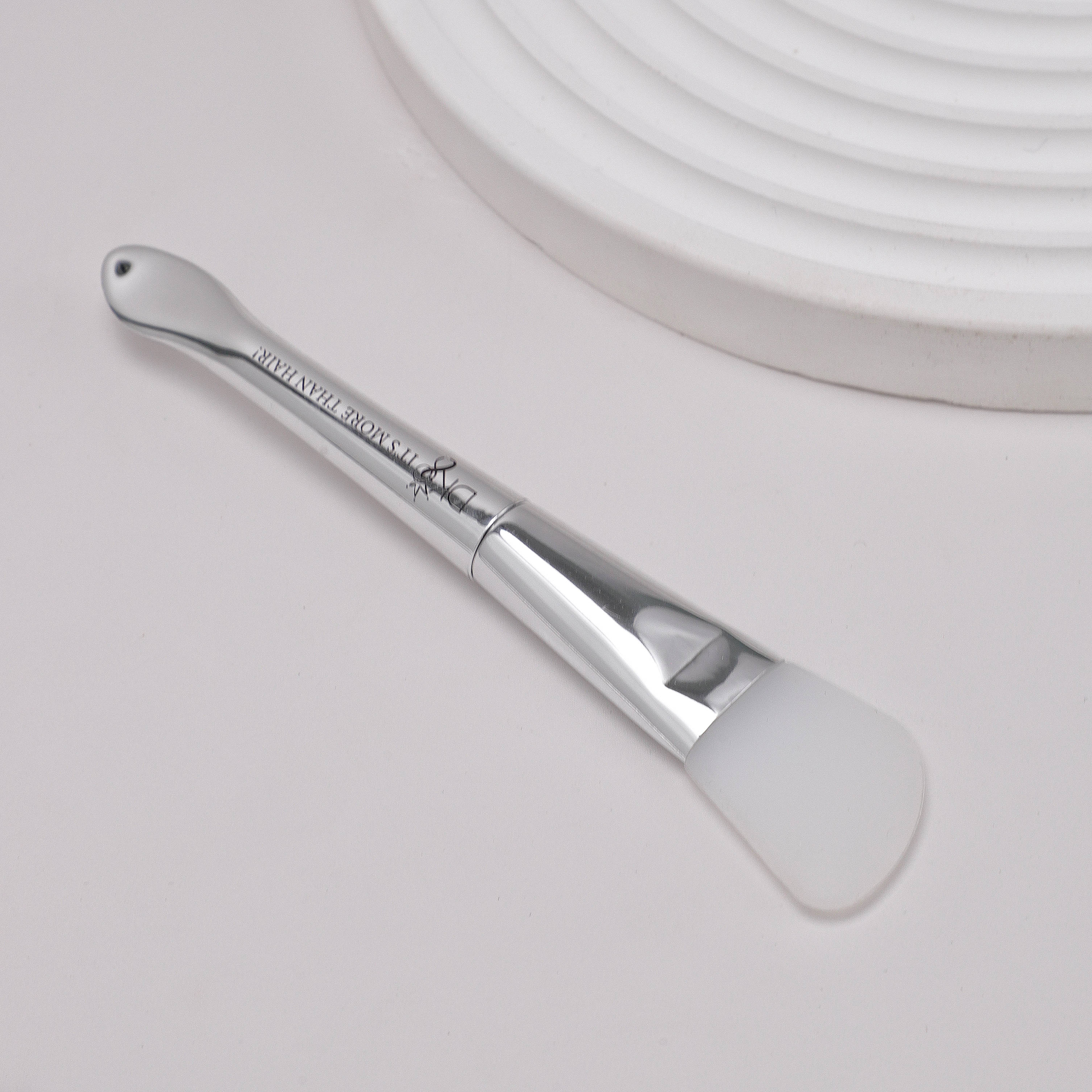 DKEIGHT™ Silicone Angle Brush on side white background with decoration - Silicone wig glue applicator