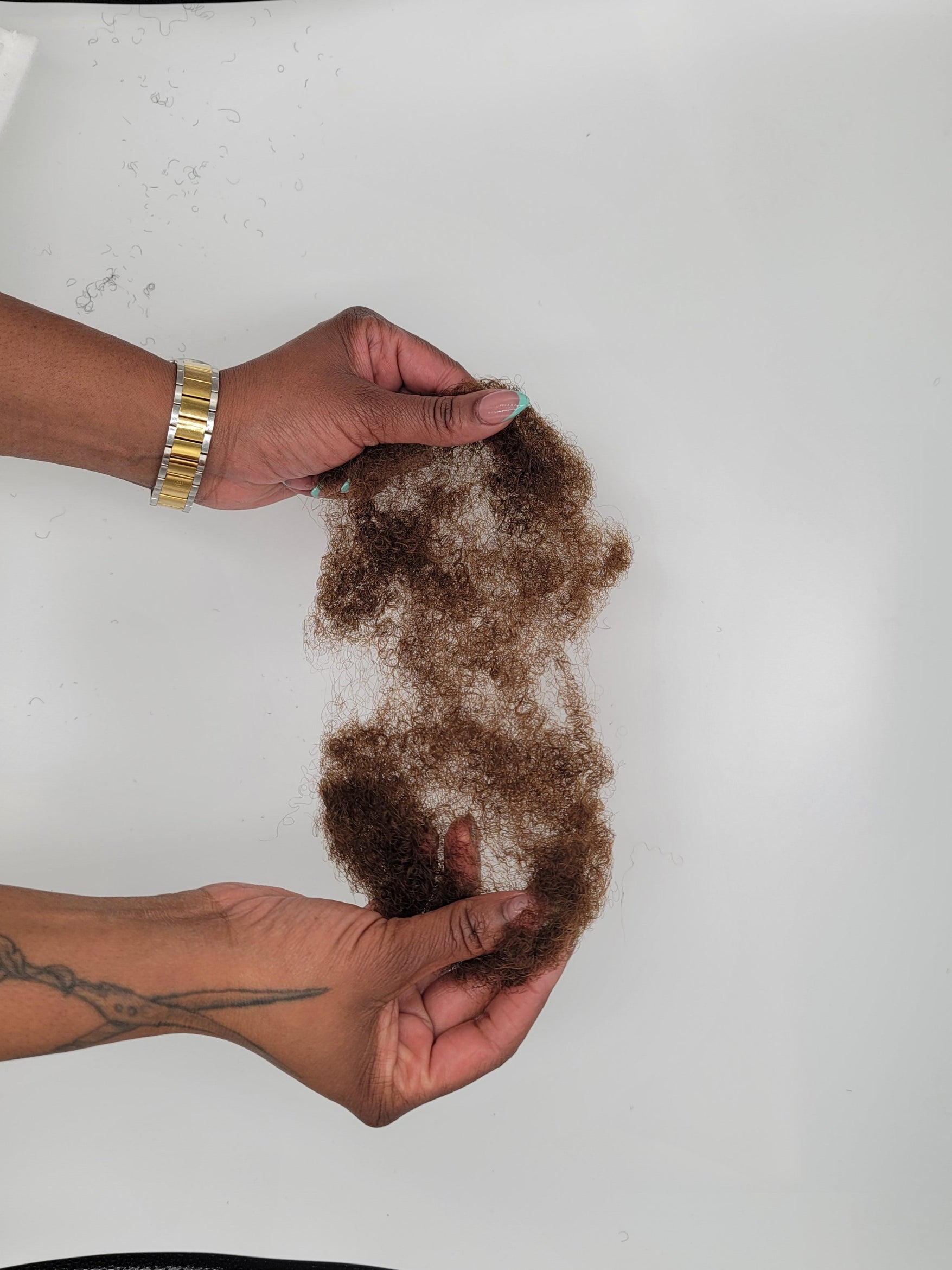 Person holding DKEight bundle of loose bulk 4C brown hair against a white background 