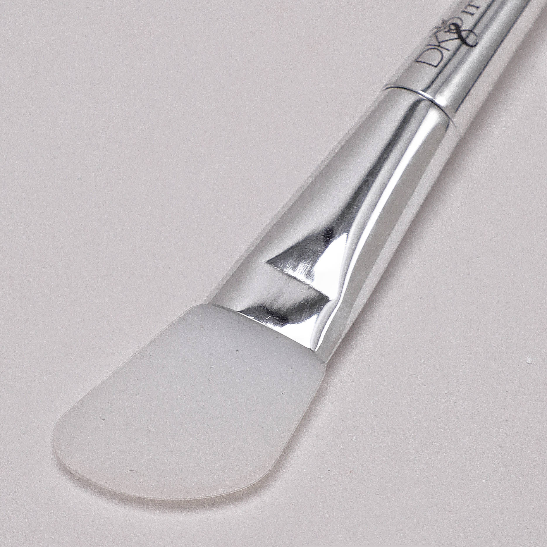 Close up of DKEIGHT™ Silicone Angle Brush bristle white background - Silicone wig glue applicator